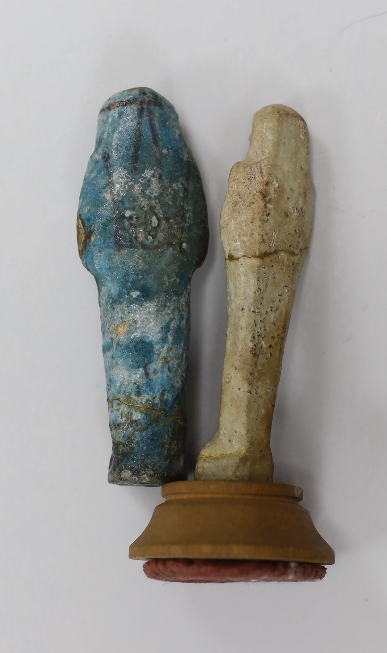 Two Egyptian glazed faience ushabti, one on wooden base, 9.6cm high. Provenance - collected before 1940